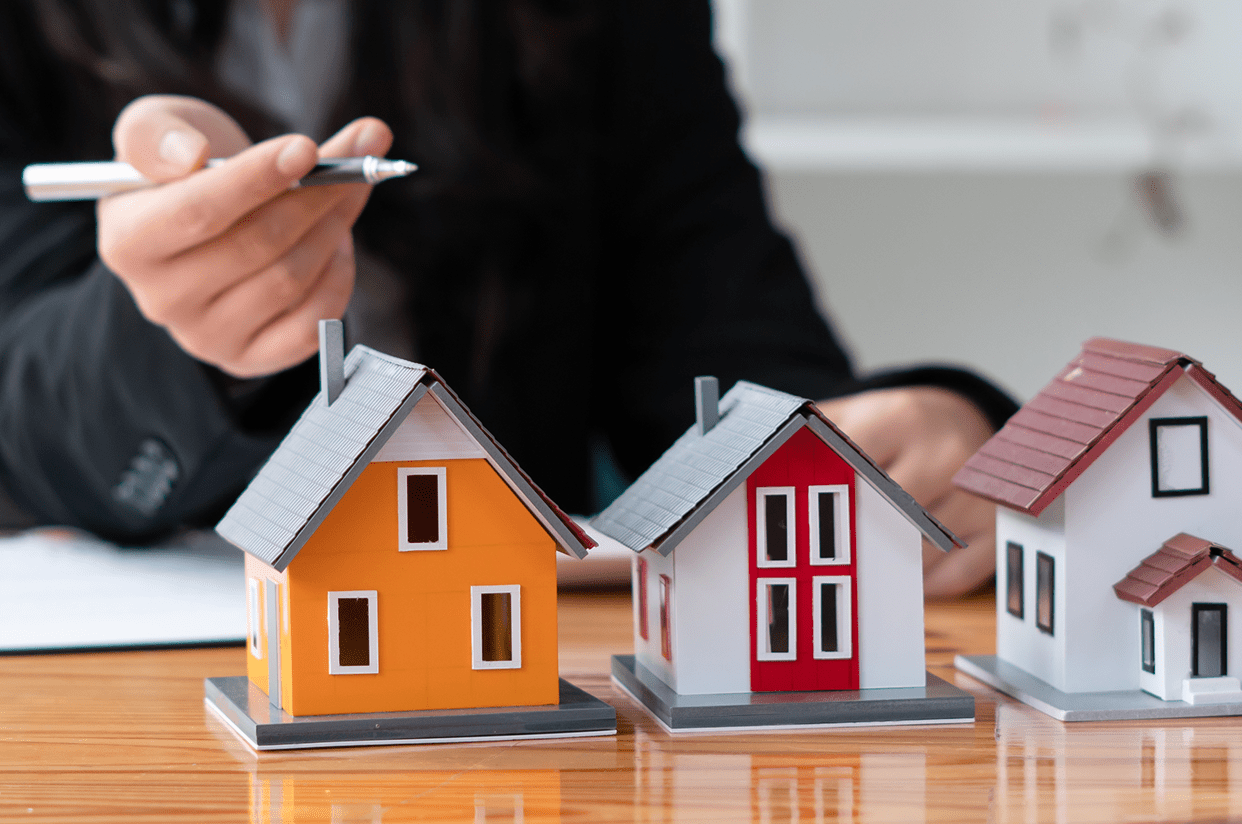 Person holding pen near model houses