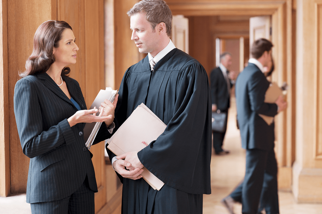 Legal professionals conversing, holding documents